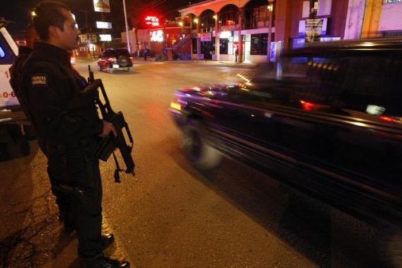 A police officer stands guard on a busy street in downtown Ciudad Juarez