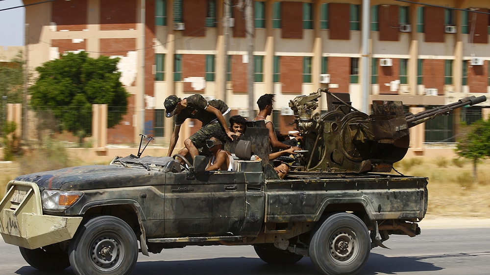 Fighters loyal to the UN-recognised Government of National Accord (GNA), geare transported on board of a military vehicle during clashes with forces loyal to strongman Khalifa Haftar, in Espiaa, abou