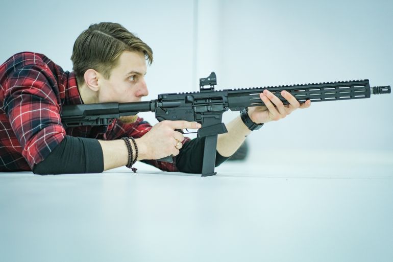 A photo of a man holding a gun.