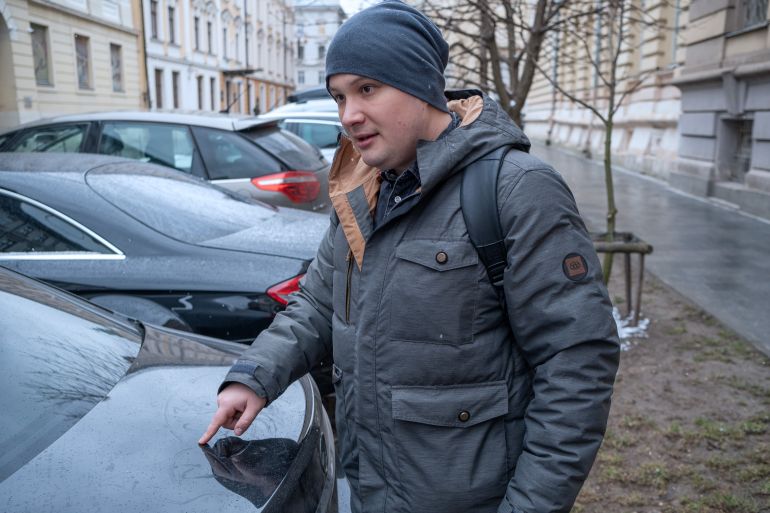 A photo of a man near some parked cars.