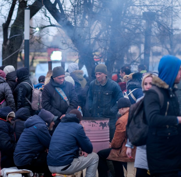 A photo of a group of people with a metal container in the middle.