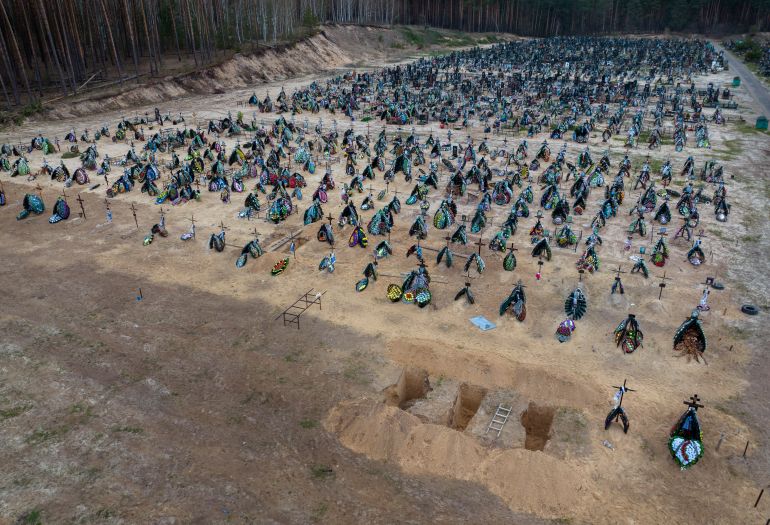 Three dug graves are ready for the next funerals at the cemetery in Irpin, on the outskirts of Kyiv, Ukraine, Tuesday, April 19, 2022.