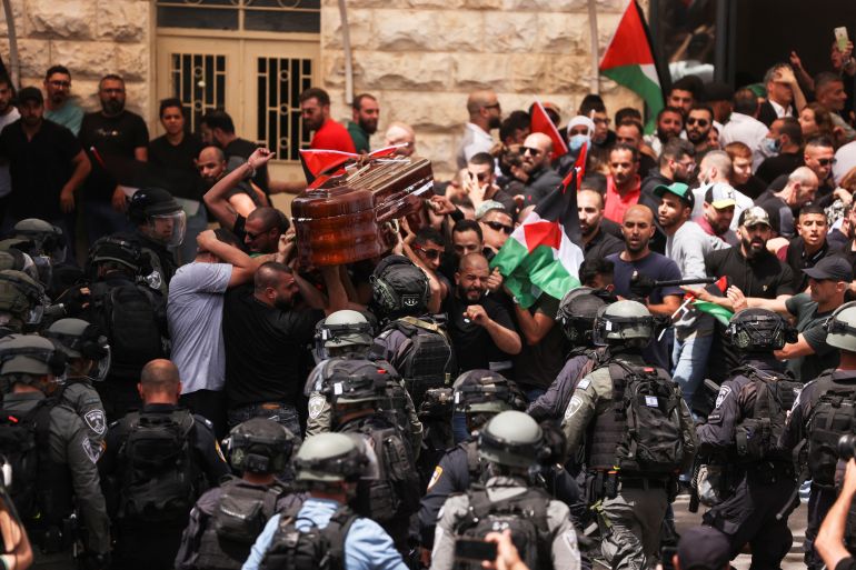Family and friends carry the coffin of XEn News reporter Shireen Abu Akleh, who was killed during an Israeli raid in Jenin in the occupied West Bank, as clashes erupted with Israeli security forces, during her funeral in Jerusalem