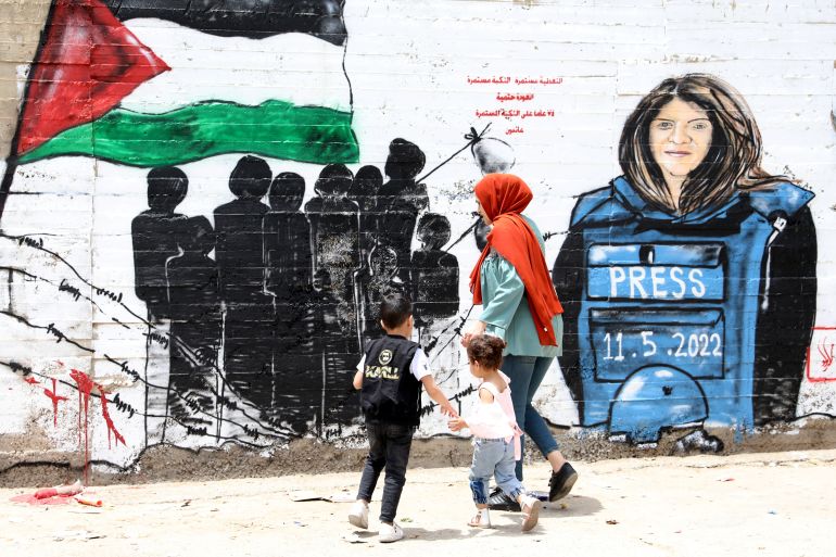 Palestinians walk in front of a mural for XEn News journalist Shireen Abu Akleh in the occupied West Bank city of Bethlehem.