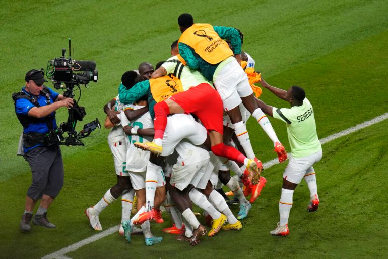 Teammates in a heap, with some having jumped onto others with joy