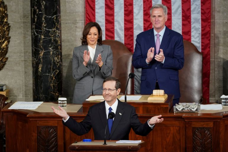 Isaac Herzog stands on podium in front of Kamala Harris and Kevin McCarthy