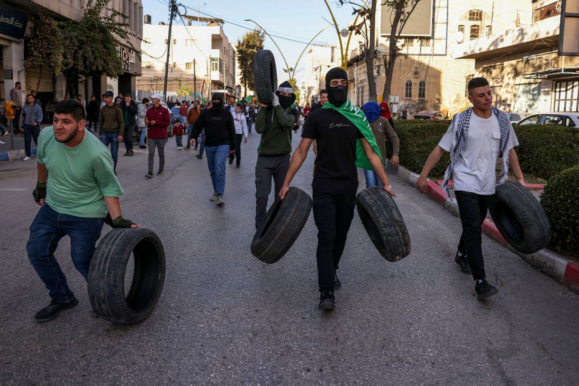 Palestinian protestors carry tyres during a rally supporting the Gaza Strip amid ongoing battles between Israel and the Palestinian movement Hamas, on December 11