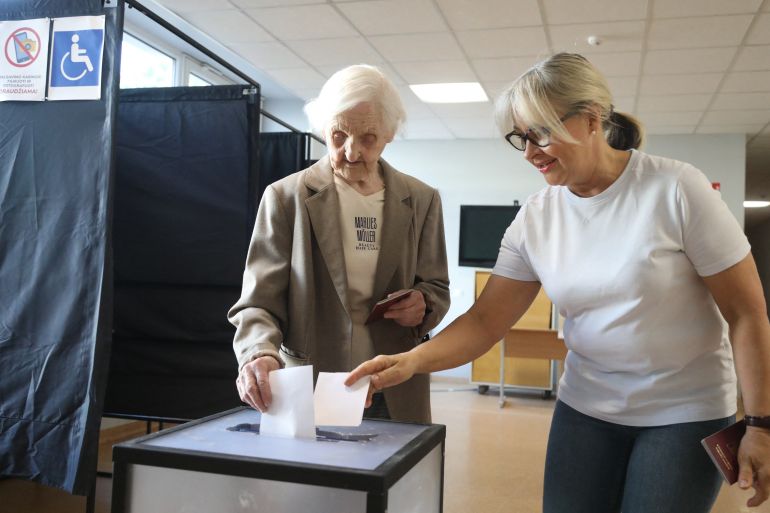 Voters in Lithuania cast their ballot during the second round of the presidential election at a polling station in capital Vilnius