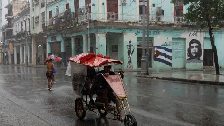 People pass by on the street as Hurricane Rafael passes by Havana, Cuba, November 6, 2024. [REUTERS/Alexandre Meneghini]