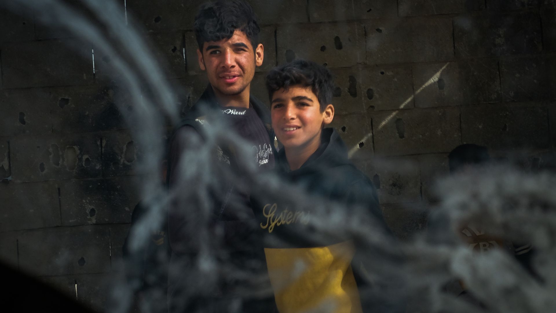Two boys walk past a security patrol
