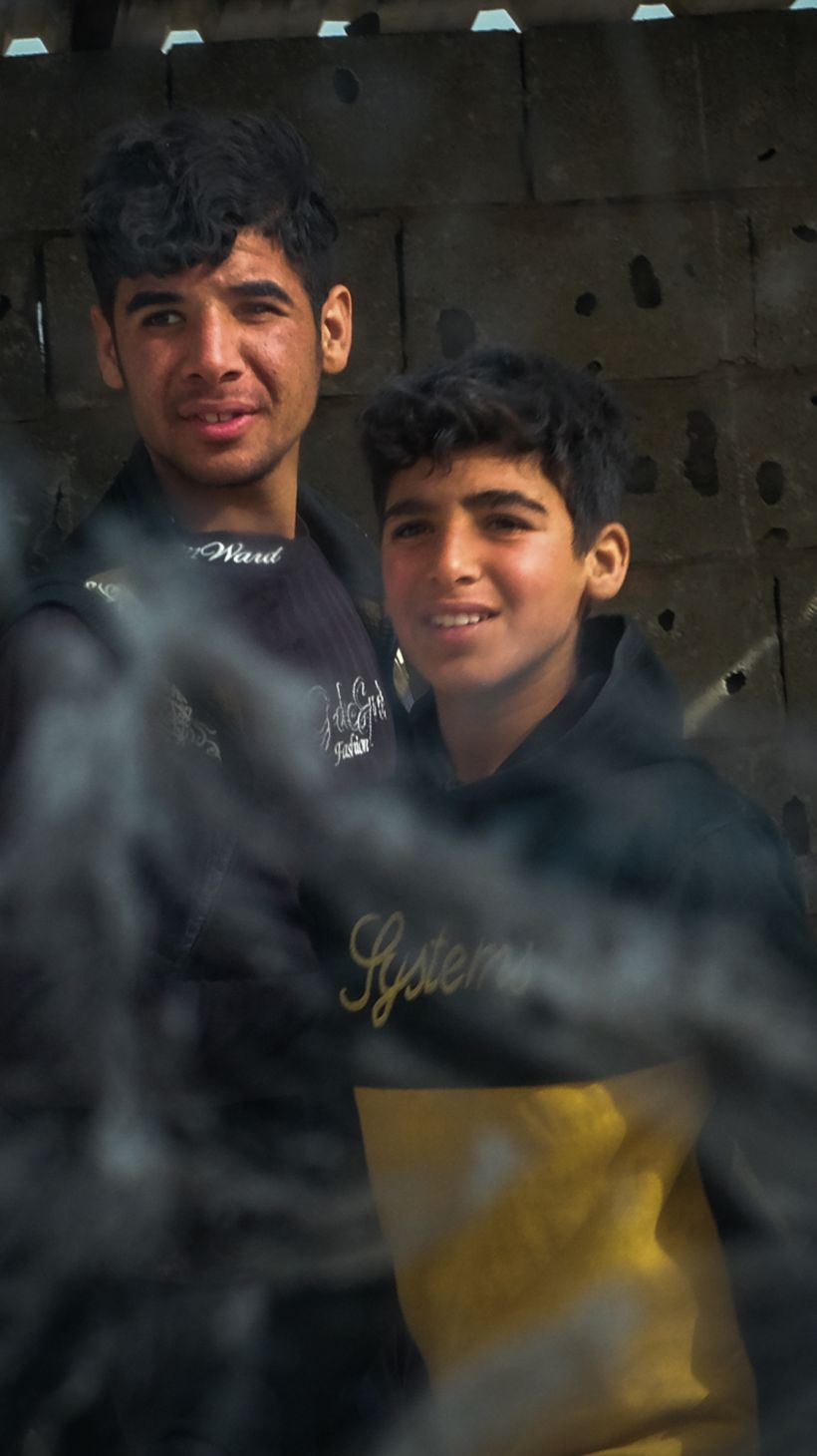 Two boys walk past a security patrol