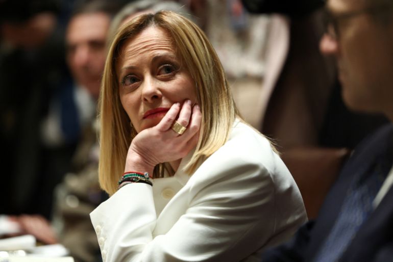 Giorgia Meloni leans her head on her hand at the US cabinet table.