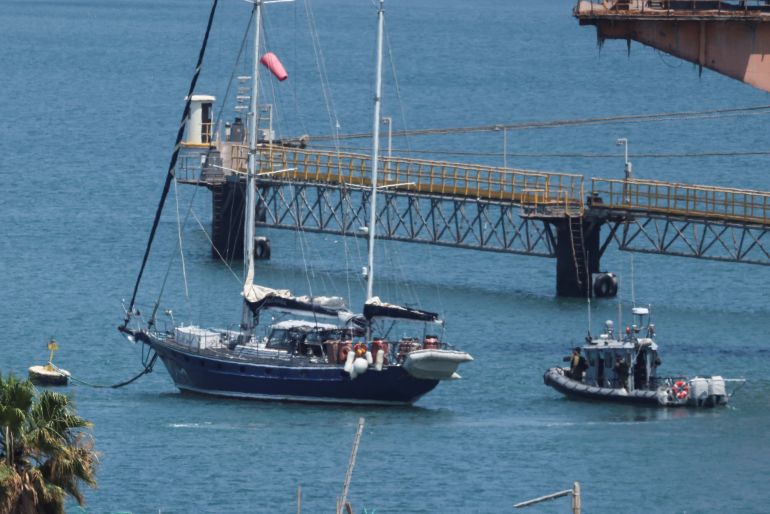 Gaza-bound British-flagged yacht "Madleen" is docked next to a military boat Ashdod port following a takeover by the Israeli army, in Ashdod, Israel, June 10, 2025 [Nir Elias/Reuters]