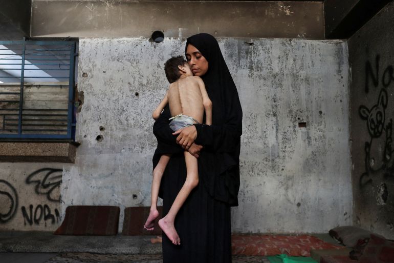 Displaced Palestinian mother Samah Matar holds her malnourished son Youssef, who suffers from cerebral palsy, at a school where they shelter amid Israel's forced starvation policy, in Gaza City, July 24, 2025. [Mahmoud Issa/Reuters]