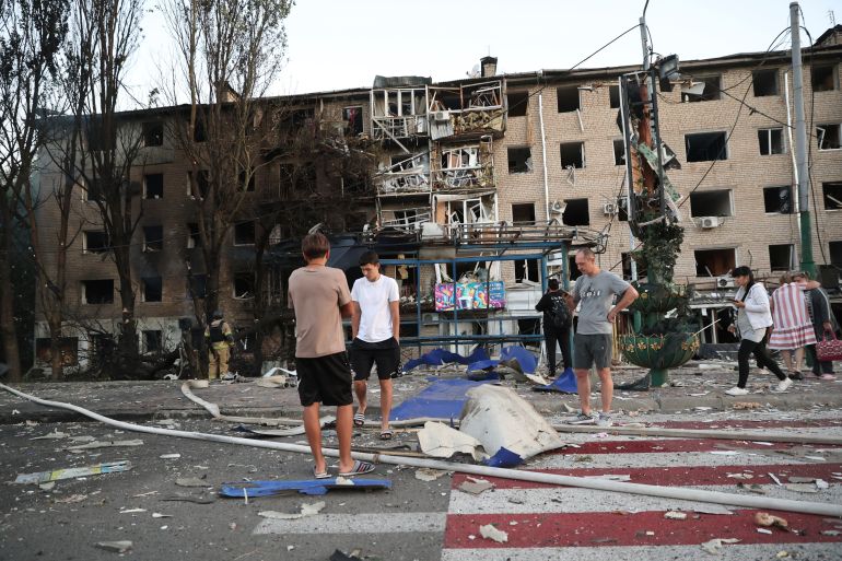 Local residents stand near their destroyed home following Russian air strike in Zaporizhia, Ukraine,