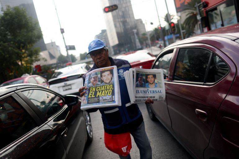 A newspaper vendor walks through traffic selling newspapers reporting the El Paso, Texas, U.S., arrest of Mexican drug lord Ismael "El Mayo" Zambada and Joaquin Guzman Lopez, "El Chapo" Guzman’s son, in Mexico City, Mexico July 26, 2024. REUTERS/Gustavo Graf
