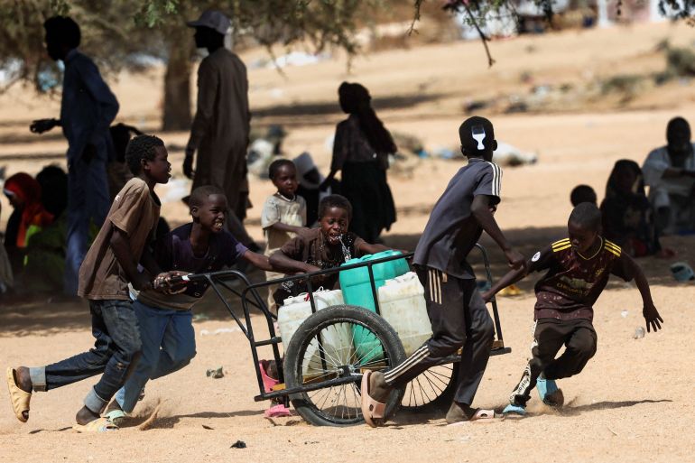 Sudanese refugee boys from Darfur carry canisters at the Iridimi refugee camp in Wadi Fira province, Chad