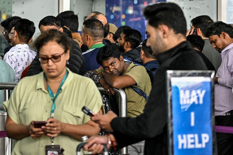 Passengers wait outside the IndiGo Airlines kiosk at the Kempegowda International Airport in Bengaluru