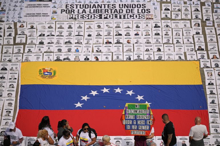 Images of Venezuelan prisoners surrounding a huge Venezuelan flag at a protest calling for prisoners to be released.