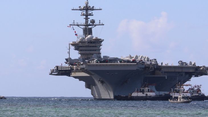 Harbor tug boats guide Nimitz-class aircraft carrier USS Abraham Lincoln as the ship pulls into Naval Base Guam for a scheduled port visit, December 11, 2025. [Valerie Maigue/US Navy]